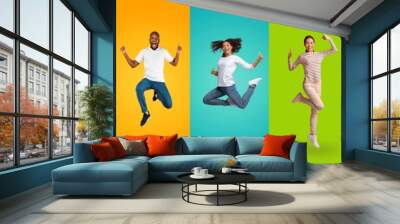 Joyful multiracial people jumping up on colorful backgrounds, showing like Wall mural