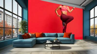 Joyful sporty african girl exercising, looking at free space Wall mural