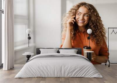 Joyful woman on call with coffee cup Wall mural