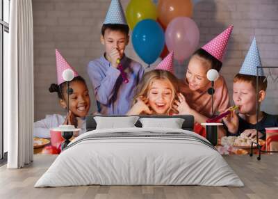 Kids looking at birthday cake with candles Wall mural