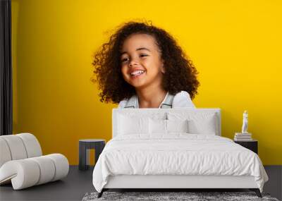 Laughing cute afro girl portrait, yellow background Wall mural