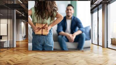 Little girl greeting her dad with Fathers Day, holding gift behing back Wall mural