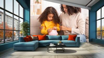 Little Girl Putting Money To Piggybank Sitting With Mother Indoor Wall mural