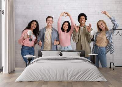 Love, friendship, youth, lifestyle. Teen happy multiracial friends gesturing with hands Wall mural