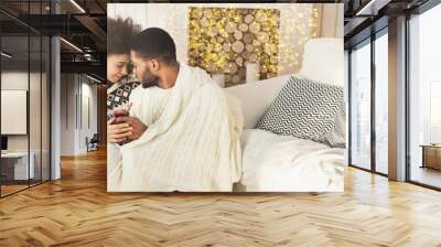 Loving african-american couple drinking mulled-wine in cozy room Wall mural