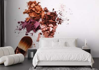 Makeup brushes with blush or eyeshadow of pink, red and coral tones sprinkled on white background Wall mural