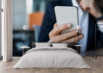 Male entrepreneur using smartphone at workplace, browsing business app or chatting with client, selective focus Wall mural