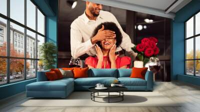 Man Covering Woman's Eyes Holding Bouquet Celebrating Valentine In Restaurant Wall mural