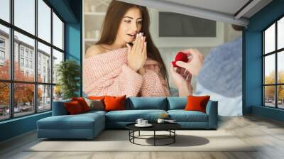 Man giving engagement ring to surprised woman at home Wall mural