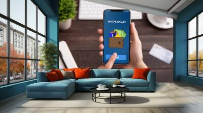 Man holding smartphone with digital wallet application Wall mural