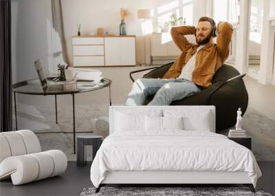 Man Listening Music Wearing Headphones Resting In Chair Indoor, Panorama Wall mural