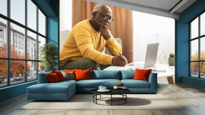 Mature Black Male Freelancer Using Laptop Taking Notes Working Indoors Wall mural