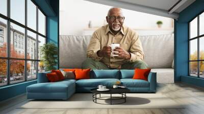 Mature Black Man Drinking Coffee Sitting On Sofa At Home Wall mural