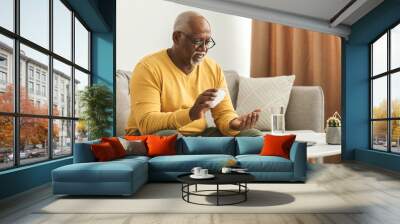 Mature Black Man Taking Medication Pill At Home Wall mural