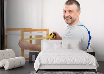 Mature Man Making Wooden Shelf Smiling To Camera Indoors Wall mural