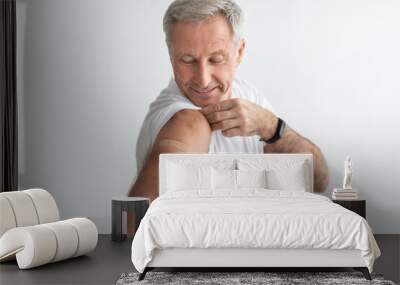 Mature Man Posing After Coronavirus Vaccination Showing Arm, Gray Background Wall mural