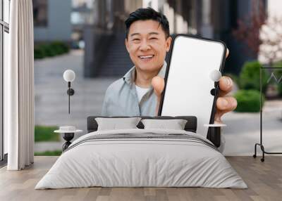 Middle Aged Asian Man Showing Smartphone With Blank Screen At Camera Wall mural