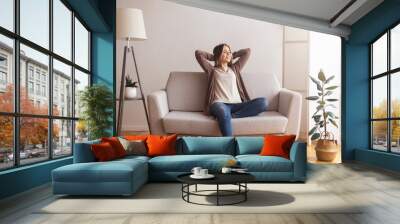 Millennial girl relaxing at home on couch Wall mural