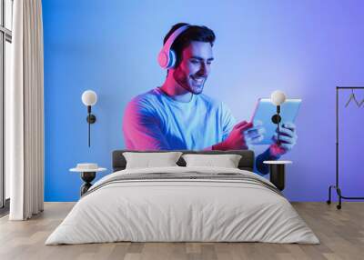 Modern games with devices. Man playing at tablet Wall mural