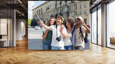 Multiethnic friends recording video with monopod outdoors Wall mural