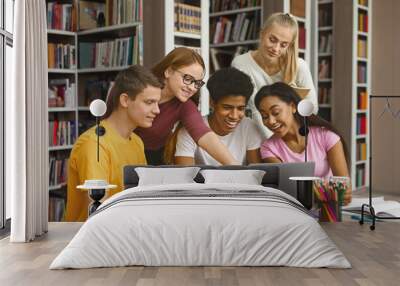 Multinational Team Of College Students Talking Over Project, girl pointing at laptop screen, library interior Wall mural