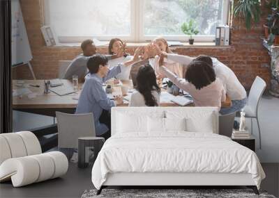 Multiracial business team giving high five in office during meeting Wall mural