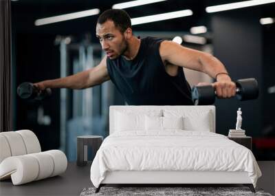 Muscular Black Young Man Doing Dumbbell Lateral Raise Exercise At Gym Wall mural