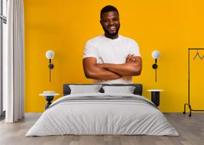 Muscular young african man standing with his arms crossed Wall mural