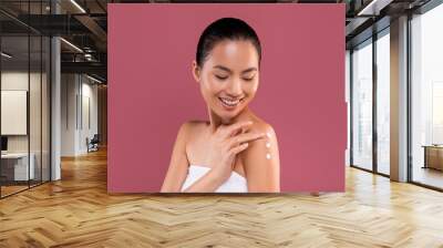 Naked asian lady with body lotion on her shoulder Wall mural