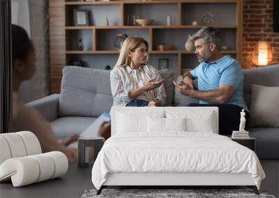 Offended sad nervous adult caucasian husband and wife swear at meeting with psychologist Wall mural