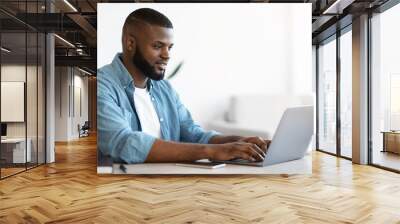 Online Career. Portrait Of Young Black Male Freelancer Typing On Laptop Wall mural