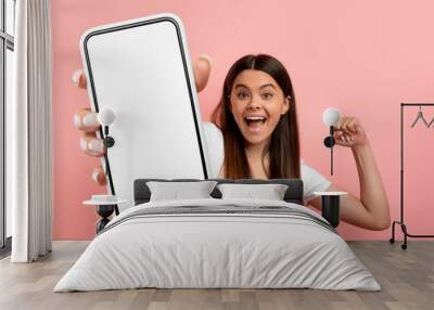 Overjoyed teen girl celebrating success, showing big phone Wall mural