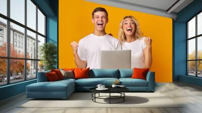 Overjoyed young guy and girl celebrating win with laptop Wall mural