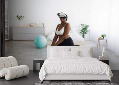 Overweight young black lady in VR headset exercising with virtual reality app at home Wall mural