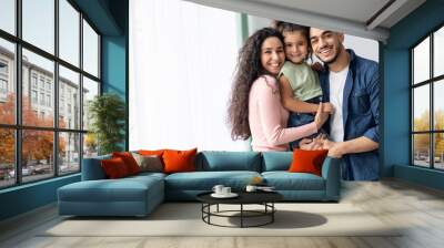 portraif of happy arabic parents posing with their little daughter at home Wall mural