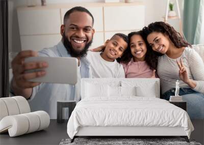 Portrait of black family taking selfie together at home Wall mural