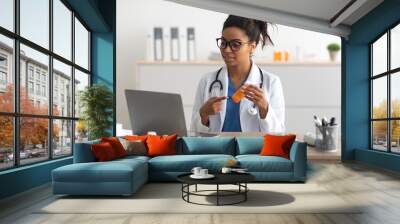 Portrait of black female medical practitioner using laptop Wall mural