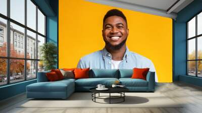 Portrait of cheerful bearded black man over yellow background Wall mural