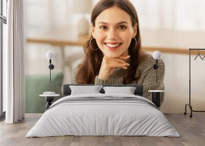 Portrait of cheerful brunette young woman posing at home Wall mural