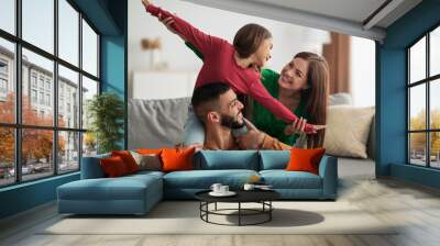 Portrait of cheerful happy Arab family having fun at home Wall mural