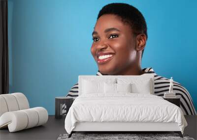 Portrait Of Cheerful Overweight African Lady Looking Aside, Blue Background Wall mural