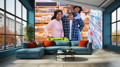 Portrait of happy black family posing together at grocery store Wall mural