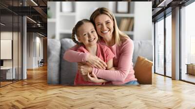 Portrait Of Happy Caucasian Mother And Cute Little Daughter Embracing At Home Wall mural