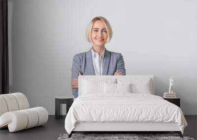 Portrait of happy confident businesswoman standing with crossed arms on light studio background, panorama Wall mural