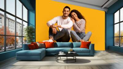 Portrait Of Happy Smiling Young Arabic Couple Posing Over Yellow Background Wall mural