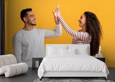 Portrait Of Happy Young Arab Couple Giving High Five To Each Other Wall mural