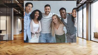 Portrait of happy young business team posing over grey background Wall mural