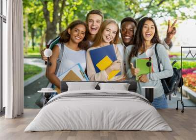 Portrait of international happy students posing in park, walking in city after studying Wall mural