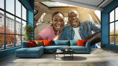 Portrait of joyful african couple in car Wall mural