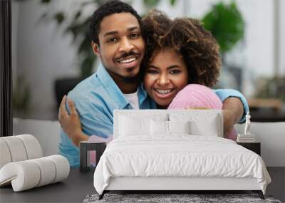 Portrait of loving happy young black couple embracing Wall mural